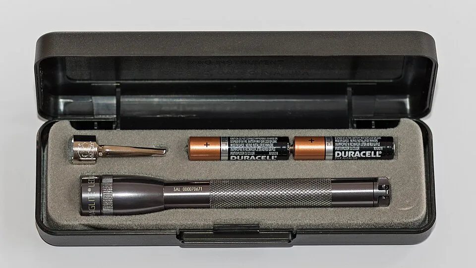 An LED flashlight and spare batteries in a protective case